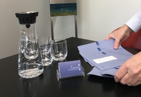 Waterkaraf en dossiermappen op de overlegtafel